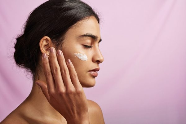 Woman applying moisturizer on the skin