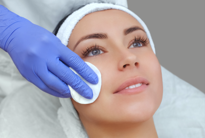 woman getting face wiped before facial procedure